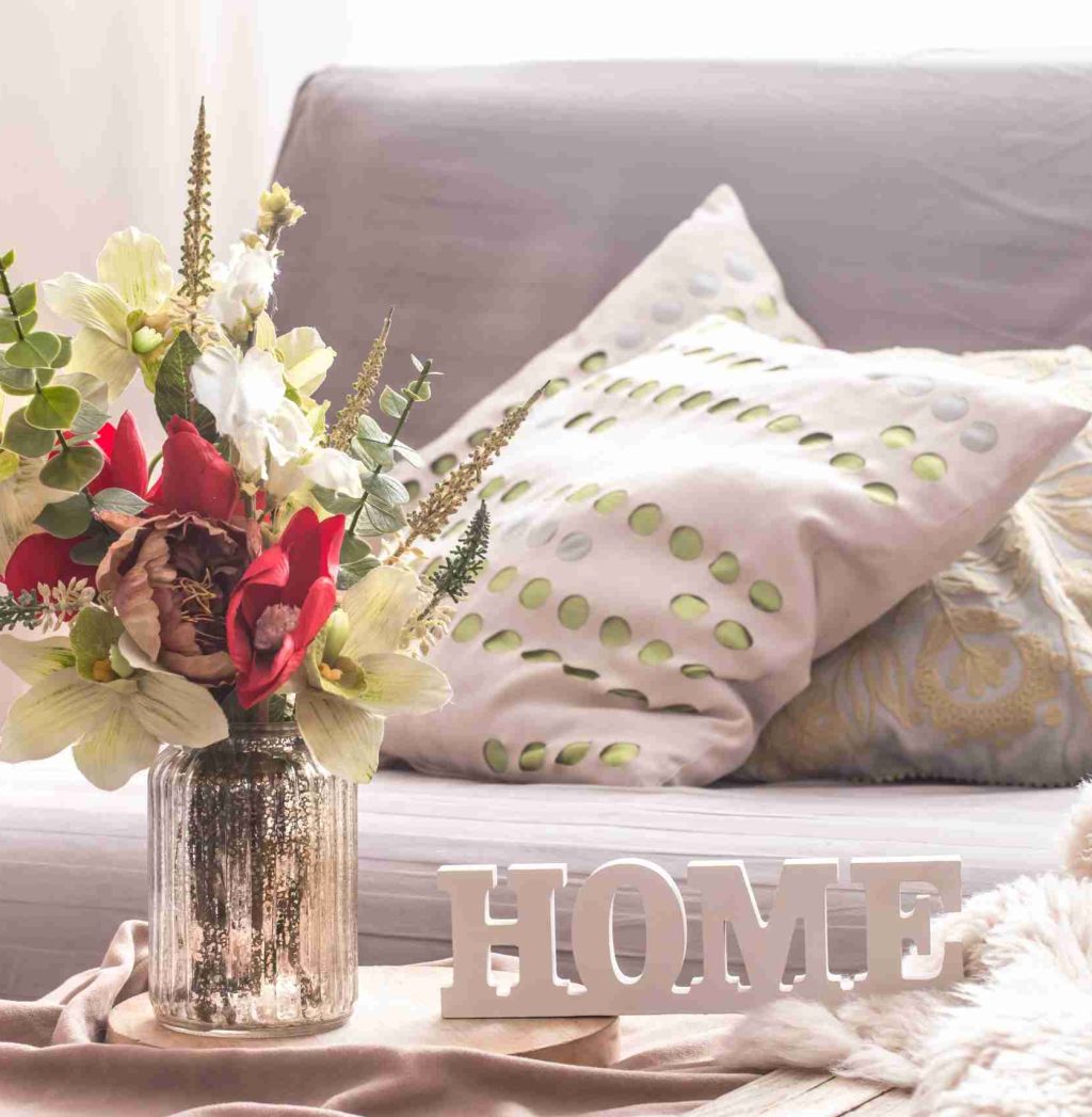 Homely cozy spring interior in the living room with a vase and flowers, home comfort concept
